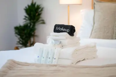 a stack of towels on a bed with a book at New Listing Sunset Retreat by Colby&Conrad in Los Angeles