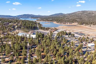 an aerial view of a resort with a lake and mountains at Tall Pines Retreat Large Patio w BBQ and Firepit! in Big Bear City Airport