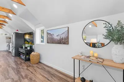 a living room with a table and a mirror at Tall Pines Retreat Large Patio w BBQ and Firepit! in Big Bear City Airport