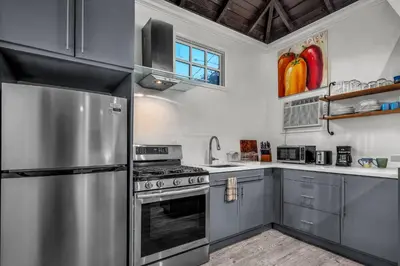 a kitchen with stainless steel appliances and a window at Villa Victoria Guest House in Los Angeles