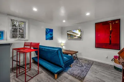 a living room with a blue chair and a table at Villa Victoria Guest House in Los Angeles