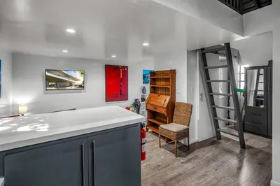 a kitchen with a counter and a room with a ladder at Villa Victoria Guest House in Los Angeles