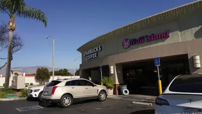 a car parked in a parking lot in front of a mallstand at \u963f\u5c14\u7f55\u5e03\u62c9\u6c11\u5bbf in Alhambra