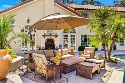 a patio with a couch and an umbrella at Marbella Lane - Tranquil Country Escape Getaway in Placentia