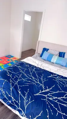a bedroom with a bed with a blue comforter at Huge bedroom with shared bathroom in Ontario