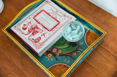 a tray with a book and a clock on a table at Lush Venice Beach Oasis Home -just steps to beach in Los Angeles