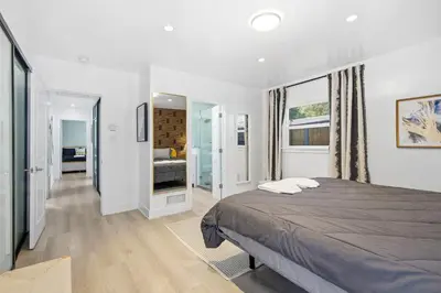 a bedroom with a large bed and a bathroom at Bel Air Very Private and Comfy Home with Jacuzzi in Los Angeles