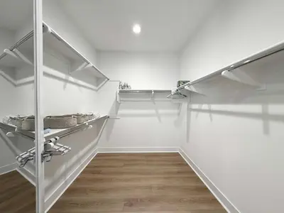 a walk in closet with white walls and white shelves at Marbella Lane Spacious 4BR Modern Family Home in Placentia