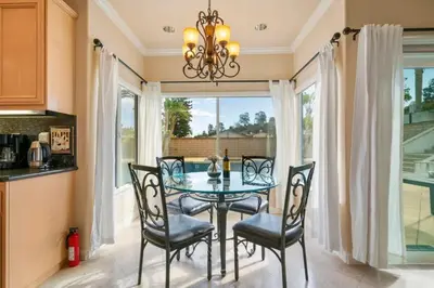a dining room with a glass table and chairs at Marbella Lane - Revitalizing Getaway w Pool in Rowland Heights
