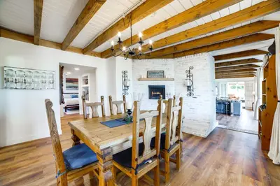 a dining room with a wooden table and a fireplace at Spacious Riverside Farmhouse, Perfectly Located in Riverside