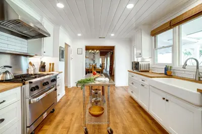 a kitchen with white cabinets and a sink and a stove at Spacious Riverside Farmhouse, Perfectly Located in Riverside