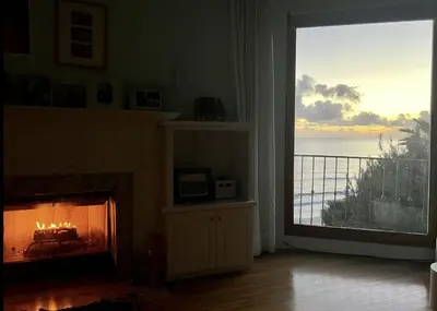 a living room with a fireplace and a view of the ocean at Villa Porto Marina - Oceanfront Living in Castellammare