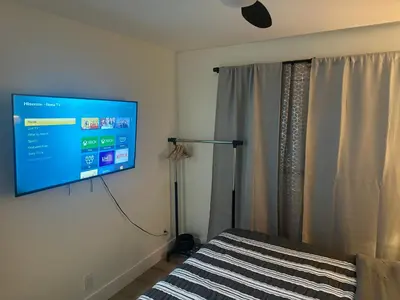 a bedroom with a flat screen tv hanging on the wall at Minimalist Room in Buena Park in Buena Park
