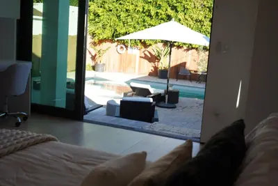 a bedroom with a door open to a patio with an umbrella at The Hollywood House in Los Angeles