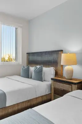 a bedroom with two beds and a lamp on a table at The Nautilus Waterfront Retreat Marina View, Pool Sauna Gym Jacuzzi in Los Angeles