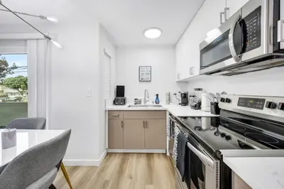 a kitchen with stainless steel appliances and a table at Oneluxstay Near Redondo Beach in Redondo Beach