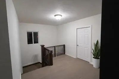 an empty hallway with a staircase and a white door at Hollywood Comfort Vibe LA in Los Angeles