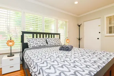 a bedroom with a black and white bed and windows at Large Room with Private Entrance in Beverly Hills - BRB1 in Los Angeles