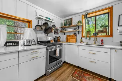 a kitchen with white cabinets and a stove at Colibri Cabin - Walk to Lake and Trails in Big Bear Lake