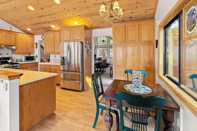 a kitchen with a table and chairs and a refrigerator at Lakeview Retreat - Walk to Lake, Close to Slopes in Big Bear Lake