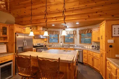 a large kitchen with wooden cabinets and a large island at Foster’s Cabin - Close to Lake and Slopes in Big Bear City