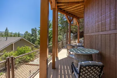 a wooden deck with a table and chairs on it at Foster’s Cabin - Close to Lake and Slopes in Big Bear City