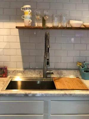 a kitchen sink with a wooden cutting board next to it at LA Beach City Studio in Harbor City