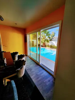 a living room with a view of a swimming pool at Entire Luxurious Vaulted Haven with Pool in Tarzana