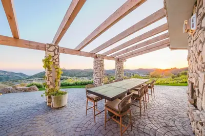 a table and chairs on a patio with a view at Mintcello Estate in Malibu