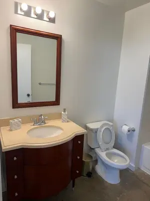 a bathroom with a sink and a toilet with a mirror at Furnished Studio Apartment in Los Angeles