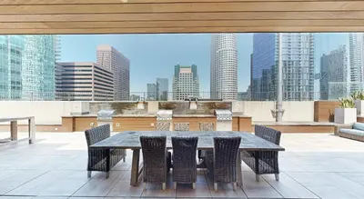 a table and chairs on a balcony with a city skyline at Furnished Studio Apartment in Los Angeles
