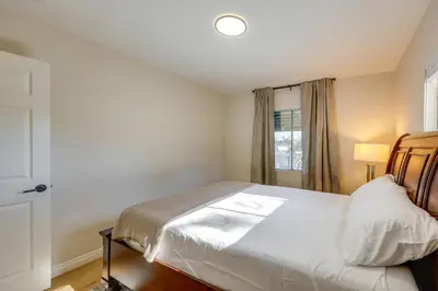 a bedroom with a white bed and a window at 1 Mi to LLUMC! Loma Linda Home with Shared Patio in Loma Linda