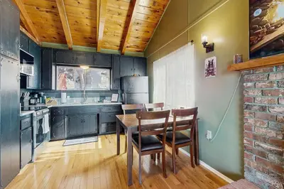 a kitchen with black cabinets and a table and chairs at Lakeview Cabin in Crestline
