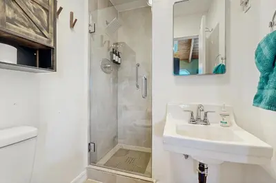 a white bathroom with a sink and a shower at Lakeview Cabin in Crestline