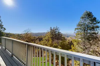 a deck with a view of the mountains at Lakeview Cabin in Crestline