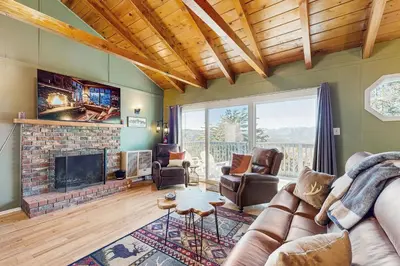 a living room with a couch and a fireplace at Lakeview Cabin in Crestline