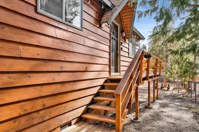 a wooden staircase leading to the side of a house at Sweet Dream Cabin on Dream Street | Walk to Alpine Slide, Dining, & Big Bear Fun in Big Bear Lake