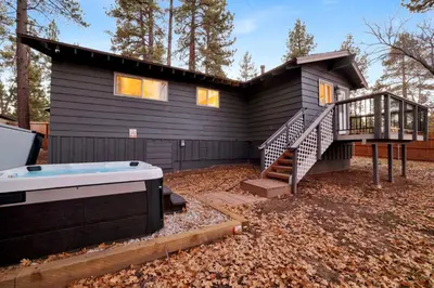 a house with a hot tub in front of it at The Highland Getaway at Big Bear Village | Downtown Modern Retreat Cottage in Big Bear Lake