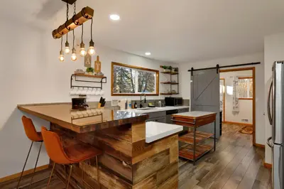 a kitchen with a large wooden island in the middle at The Highland Getaway at Big Bear Village | Downtown Modern Retreat Cottage in Big Bear Lake