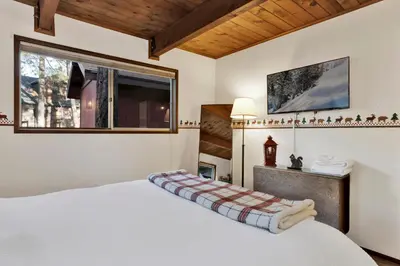 a bedroom with a white bed and a window at Willow Bear Lodge: Shuttle Stop Pet-Friendly, Walk to the Lake | Book Your Big Bear Stay! in Big Bear Lake