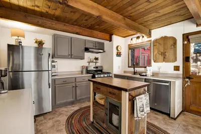 a kitchen with stainless steel appliances and a wooden ceiling at Willow Bear Lodge: Shuttle Stop Pet-Friendly, Walk to the Lake | Book Your Big Bear Stay! in Big Bear Lake