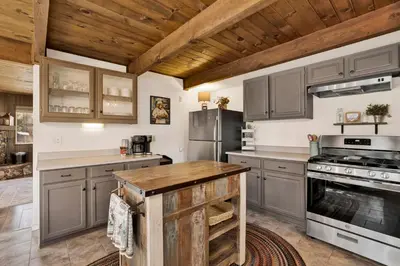 a kitchen with gray cabinets and a wooden ceiling at Willow Bear Lodge: Shuttle Stop Pet-Friendly, Walk to the Lake | Book Your Big Bear Stay! in Big Bear Lake