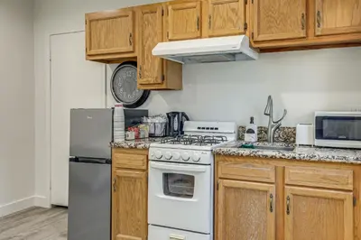 a kitchen with wooden cabinets and a white stove top oven at 5 Mi to Santa Monica Pier and Beach Chic Studio in Los Angeles