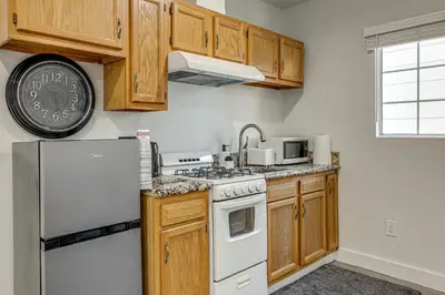 a kitchen with wooden cabinets and a white refrigerator at 5 Mi to Santa Monica Pier and Beach Chic Studio in Los Angeles