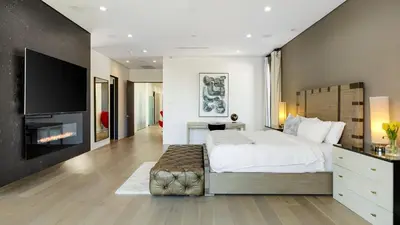 a bedroom with a large bed and a fireplace at Private LA Retreat w Pool Hot Tub Fire Pit Near Melrose Ave The Martel House by AvantStay in Los Angeles