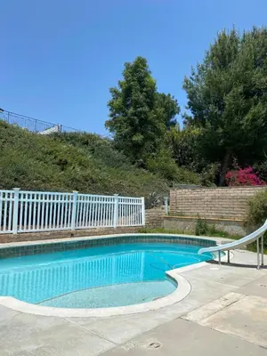 a swimming pool with a white fence around it at 530 sq ft Mini House in Walnut in Walnut