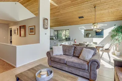 a living room with a couch and a kitchen at 2 Decks! Pet-Friendly Lake Arrowhead Cabin in Lake Arrowhead