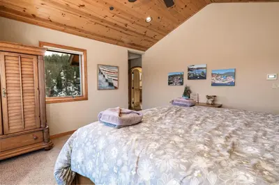 a bedroom with a large bed and a window at Boulder Cove։ Lakefront Estate in Big Bear Lake