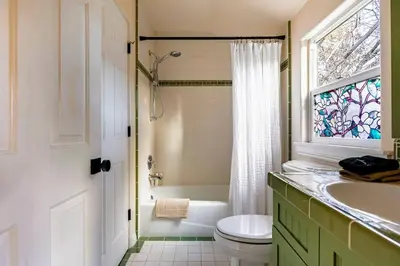 a bathroom with a sink and a toilet and a window at Lakeview Mountain Modern in Lake Arrowhead