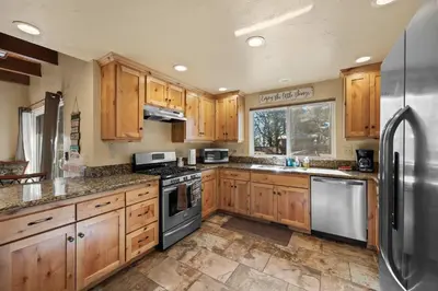 a kitchen with wooden cabinets and stainless steel appliances at The Hidden Pines Mountain Home by Navigate Stays in Running Springs